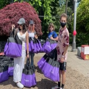 People carrying bags filled with tampons and pads to donate. 