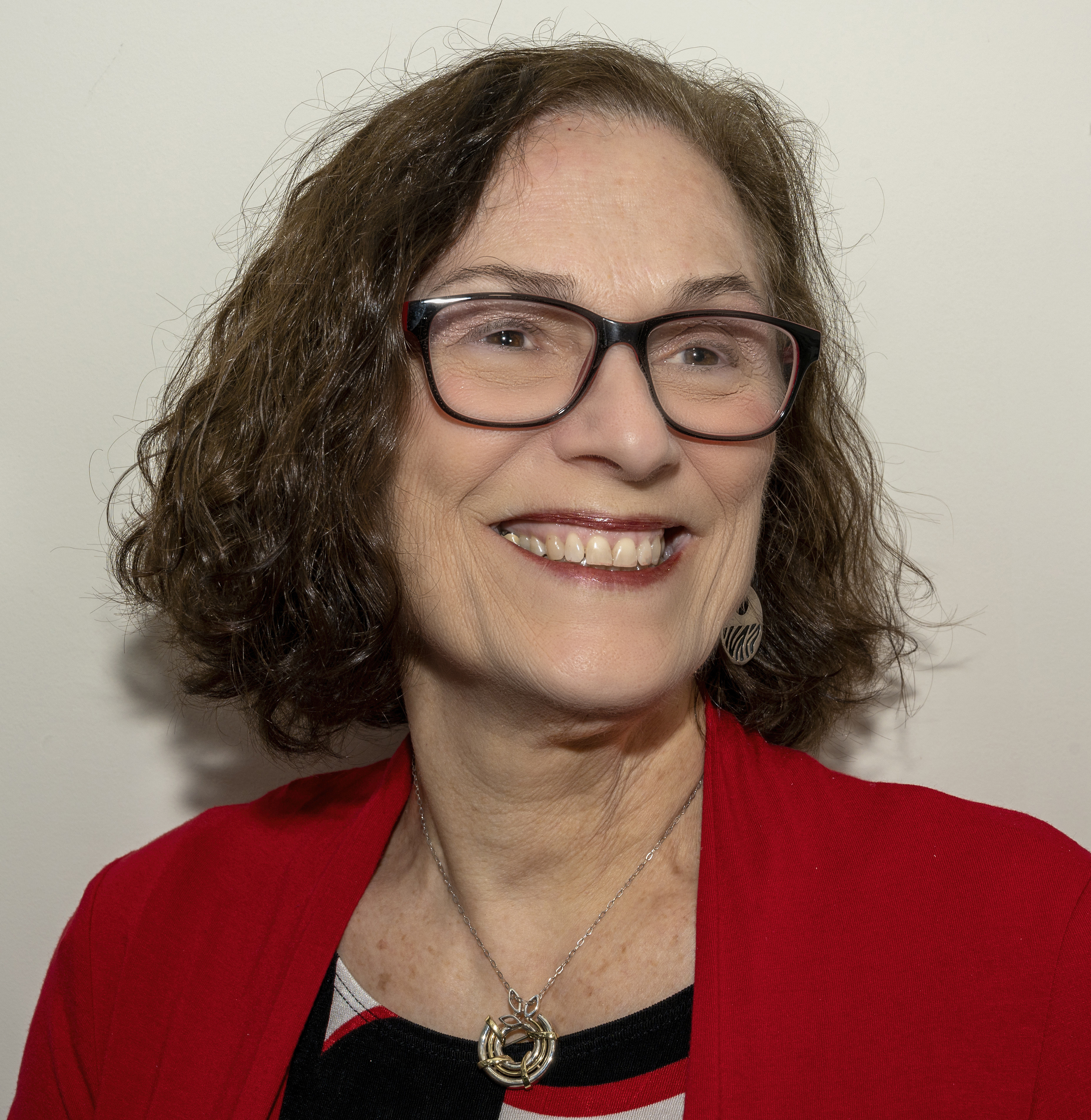 Bernice Porrazzo smiling in a red blazer and black and white shirt. 