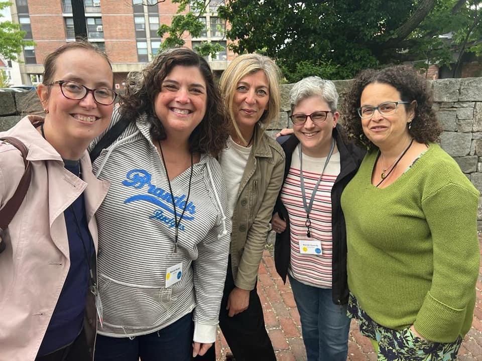 A group of women smiling and standing together 