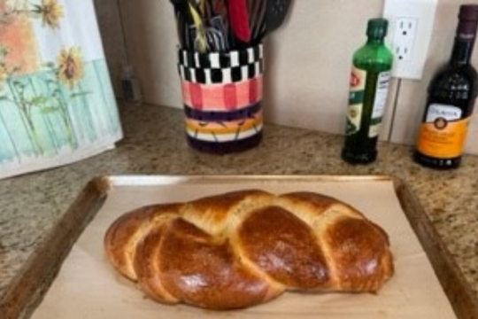 A challah on a baking tray on a kitchen counter. 